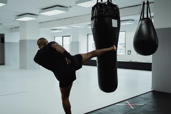 A man kicking a punching back